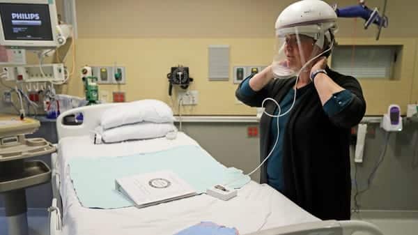 El primer caso de infección de EE. UU. Con COVID-19 se trató en el Providence Regional Medical Center, en Everett Washington. Robin Addison, una enfermera de allí, demuestra cómo usa un casco de respirador con una careta para prevenir infecciones.
