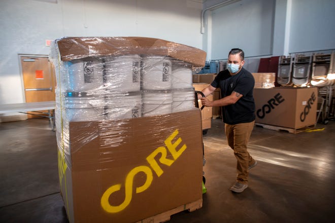 Christian Vasquez, subdirector de Strengthening Nations, empuja una paleta de kits sanitarios a través de la Primera Iglesia Metodista Unida como parte de un esfuerzo de McKinley Mutual Aid en Gallup, NM