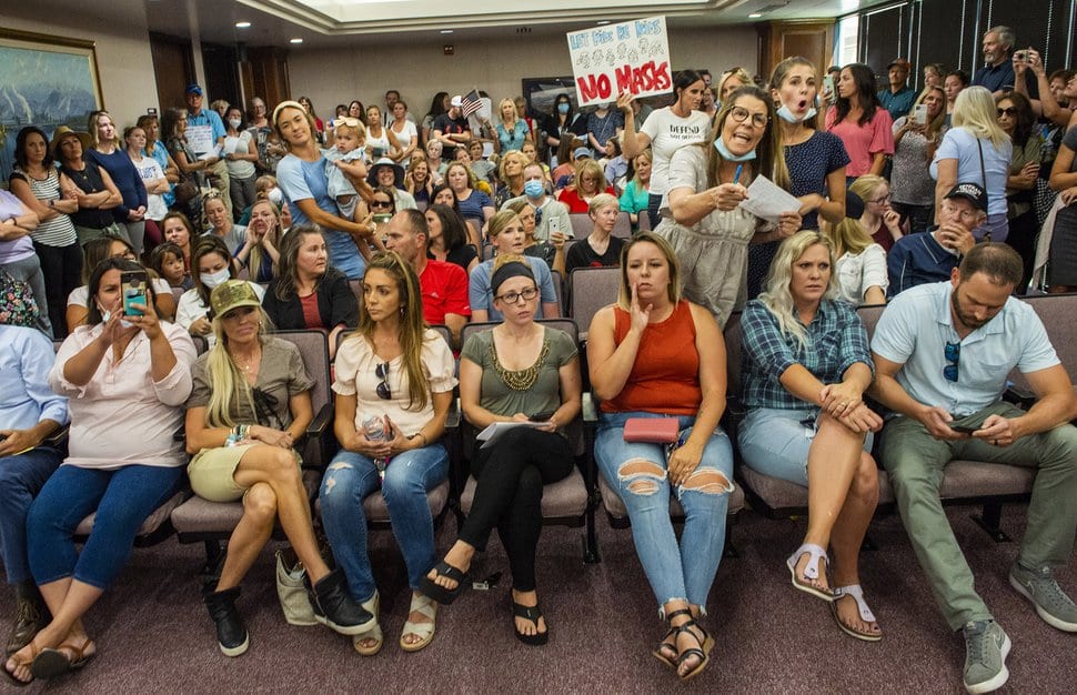 (Foto de archivo de Rick Egan | Tribune) Un grupo que protestaba contra las máscaras quitó la cinta de distanciamiento social de las sillas y llenó la sala de la Comisión del Condado de Utah el miércoles 15 de julio de 2020.